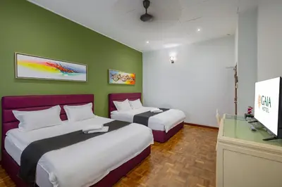 a hotel room with two beds and a flat screen tv at GAIA Hotel in Tanjung Bungah