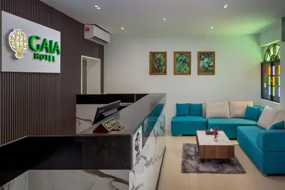a living room with a blue couch and a table at GAIA Hotel in Tanjung Bungah