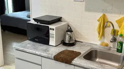 a microwave sitting on a kitchen counter next to a sink at Leisure 1Bedroom Balcony Suites Gurney in George Town