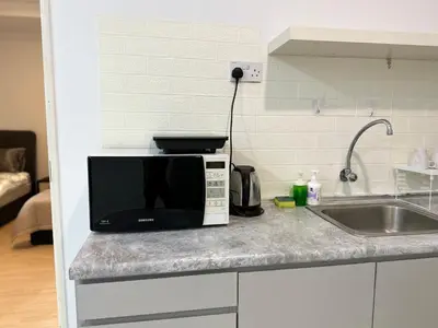 a microwave sitting on a kitchen counter next to a sink at Leisure 1Bedroom Balcony Suites Gurney in George Town