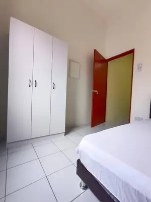 a bedroom with a bed and white cabinets and a red door at KhaAfi Homestay Seri Iskandar in Kampung Bota Kiri