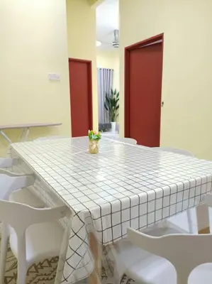 a white table with white chairs in a room at KhaAfi Homestay Seri Iskandar in Kampung Bota Kiri