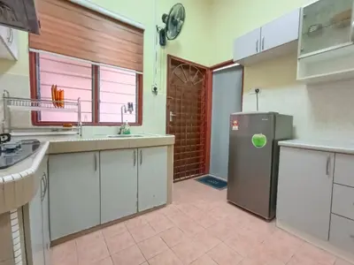 a kitchen with white cabinets and a stainless steel refrigerator at KhaAfi Homestay Seri Iskandar in Kampung Bota Kiri