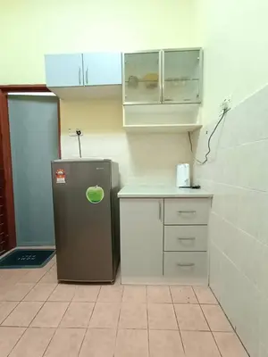 a small kitchen with a refrigerator and a counter at KhaAfi Homestay Seri Iskandar in Kampung Bota Kiri