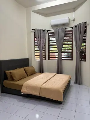 a bedroom with a bed and two windows at KhaAfi Homestay Seri Iskandar in Kampung Bota Kiri