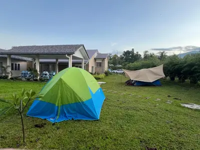 two tents in a yard in front of a house at Sunny Lake House - Entire bungalow, 5 rooms, 16 persons in Behrang Hulu