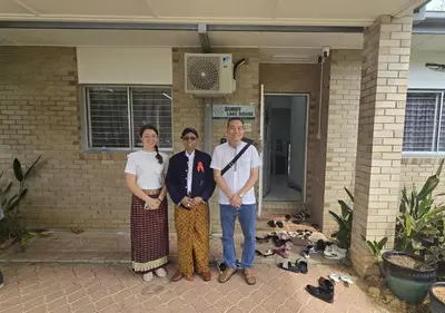 a group of three people standing in front of a building at Sunny Lake House - Entire bungalow, 5 rooms, 16 persons in Behrang Hulu