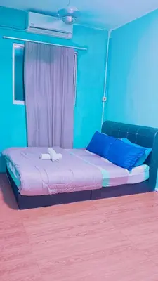 a bed in a room with a blue wall at COZY, FAMILYSTAY, BAYAN LEPAS, only 4pax, 1car parking in Bayan Lepas