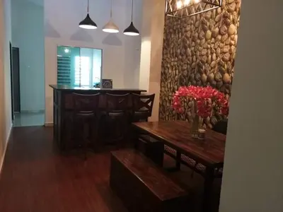 a dining room with a table with flowers on it at Imans Homestay Lumut in Seri Manjung
