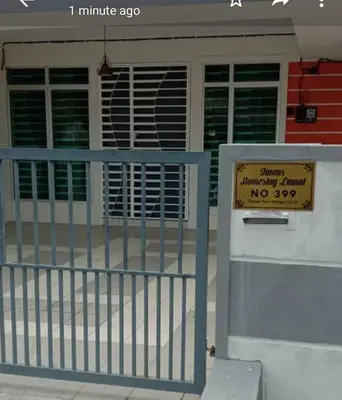 a sign on a gate in front of a building at Imans Homestay Lumut in Seri Manjung