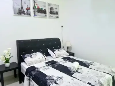 a bedroom with a bed with a black and white comforter at Imans Homestay Lumut in Seri Manjung
