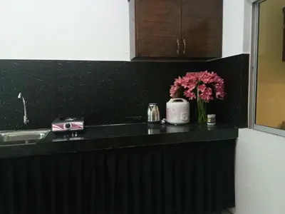 a kitchen counter with flowers in a vase on it at Imans Homestay Lumut in Seri Manjung