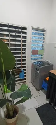 a living room with a stove and a plant at Imans Homestay Lumut in Seri Manjung