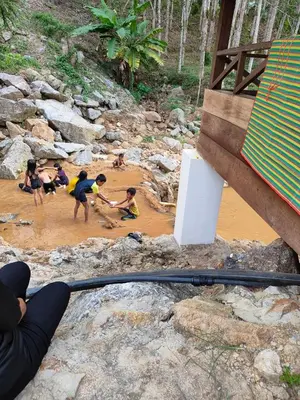 a group of children playing in the mud at Homestay Teratak D`kemangi with Private Pool in Baling