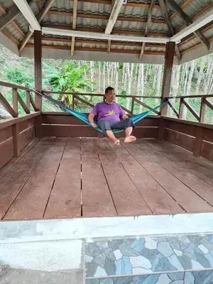 a man sitting on a hammock in a porch at Homestay Teratak D`kemangi with Private Pool in Baling