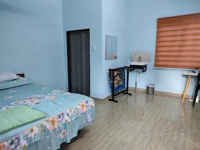 a bedroom with a bed and a desk with a window at Homestay Teratak D`kemangi with Private Pool in Baling