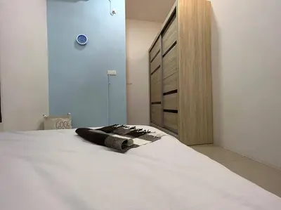 a bedroom with a white bed with a dresser at Ipoh Family Cozy Homestay 4R4B 12-13pax SY23 in Ipoh