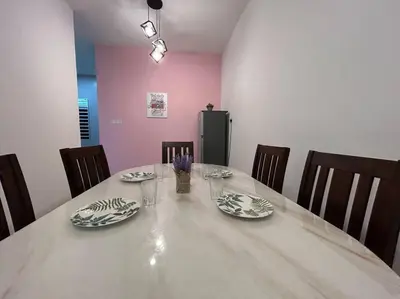 a dining room table with plates and glasses and chairs at Ipoh Family Cozy Homestay 4R4B 12-13pax SY23 in Ipoh