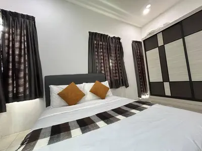 a bedroom with a large white bed with two pillows at Ipoh Family Cozy Homestay 4R4B 12-13pax SY23 in Ipoh