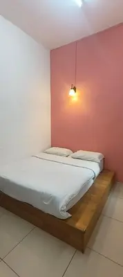 a bed in a room with a pink wall at Cameron Double Story @ Golden Hill in Brinchang