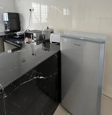 a kitchen with a counter with a refrigerator in it at Cameron Double Story @ Golden Hill in Brinchang