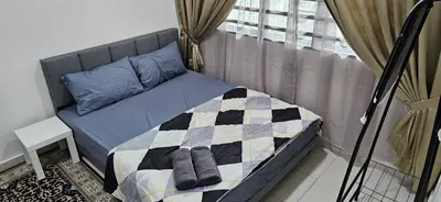 a bed with a quilt on it in a bedroom at Teluk Intan Homestay Landed 3BR2B in Teluk Intan