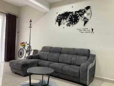 a living room with a couch and a clock on the wall at Sweet Homestay 1 The Venus Sitiawan in Sitiawan
