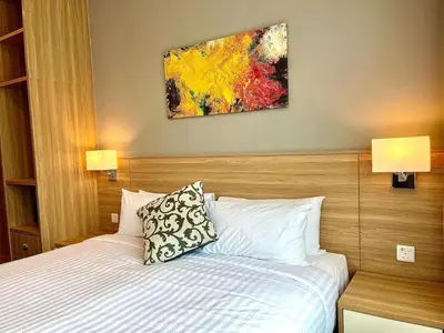 a bedroom with a bed and a painting on the wall at Hotspring 2 Room Suite @ Sunway Onsen with Theme Park View 4 to 6 pax in Tambun