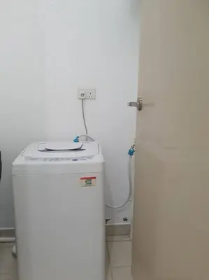 a bathroom with a toilet and a washer and dryer at Southbay Seaview Condo A16 #10minQueensbay #15minSPICE in Bayan Lepas