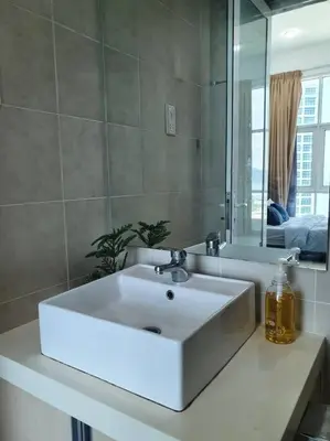 a bathroom with a white sink and a mirror at Southbay Seaview Condo A16 #10minQueensbay #15minSPICE in Bayan Lepas