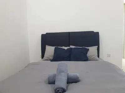 a bed with two blue towels on top of it at Southbay Seaview Condo A16 #10minQueensbay #15minSPICE in Bayan Lepas