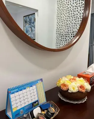 a desk with a clock and a cake in front of a mirror at Tiny House PT82 Kg Gumut Tambahan in Kalumpang