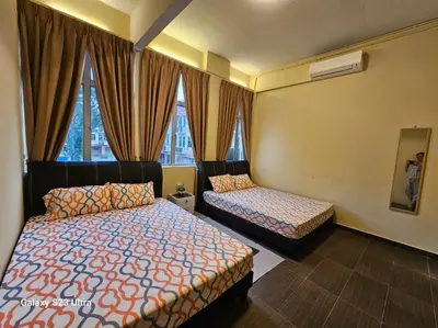 a hotel room with two beds and a window at Lumina Stay @ Kampar 16 pax in Kampar