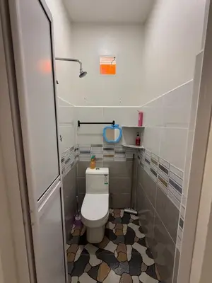 a small bathroom with a toilet and a tiled floor at Homestay Desa D Junjung Islam Guest Only in Simpang Ampat