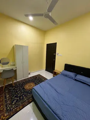 a bedroom with a blue bed and a desk at Homestay Desa D Junjung Islam Guest Only in Simpang Ampat