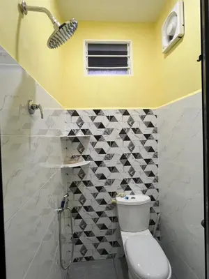 a bathroom with a toilet and a yellow wall at Homestay Desa D Junjung Islam Guest Only in Simpang Ampat