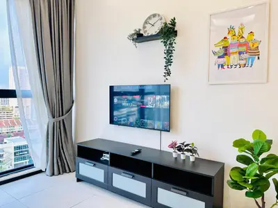 a living room with a tv on a white wall at Urban Suite Spacious 2 or 3 Bedroom and 2Bathroom at Georgetown by URBAN STAYCATION HENG COSY in Jelutong