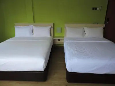 two beds sitting next to each other in a room at Merlin Hotel George Town Penang in George Town