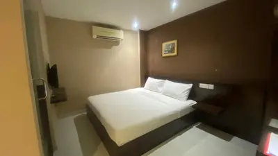 a small bedroom with a white bed in it at Hotel Vistana Micassa in Taiping