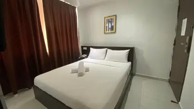 a room with a bed with a cross on it at Hotel Vistana Micassa in Taiping
