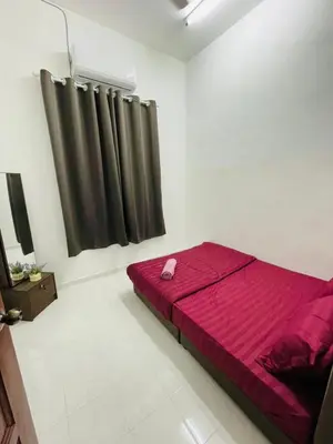 a bedroom with a bed with a red blanket at Tok Mak Homestay Bukit Mertajam in Kubang Semang