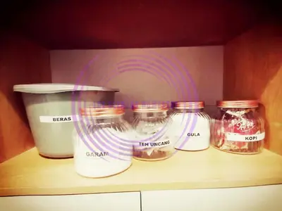 a shelf with four jars on top of a counter at The Clemira Homestay @ Sungai Karangan, Kulim, Kedah in Padang Serai