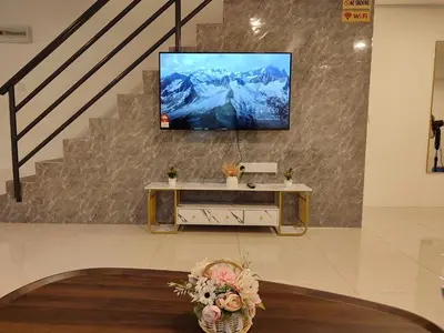 a living room with a tv on a wall at Golden 78 Ipoh Homestay in Ipoh