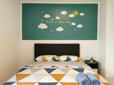 a bedroom with a bed with a painting of the sun and clouds at Golden 78 Ipoh Homestay in Ipoh
