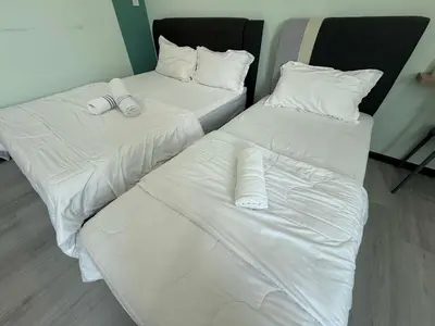 two beds in a room with white sheets and pillows at Good Night BD Motel -PEKAN BAGAN DATUK-SELF CHECK IN in Bagan Datuk