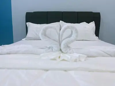 a white bed with two swans made out of towels at Good Night BD Motel -PEKAN BAGAN DATUK-SELF CHECK IN in Bagan Datuk