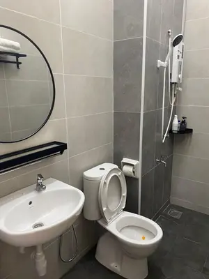 a bathroom with a sink and a toilet and a mirror at Cloud Nine Homestay in Taiping