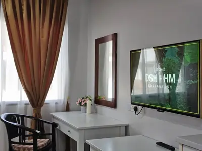 a living room with a tv and a desk with a chair at Cottage Inn Gerik in Gerik