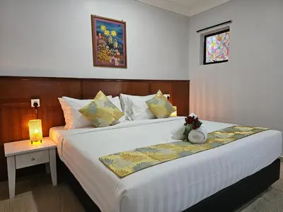 a bedroom with a large white bed with a night stand at Cottage Inn Gerik in Gerik