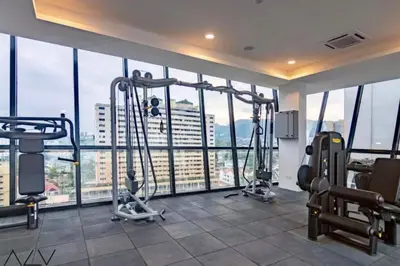a gym with cardio equipment in a large room with windows at Urban Suites, Best Seaview and Cityview in Town in Jelutong